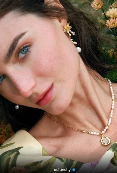 a woman with a pearl necklace and pearl earrings