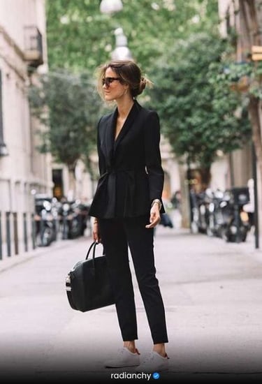 a woman in a black suit and sunglasses