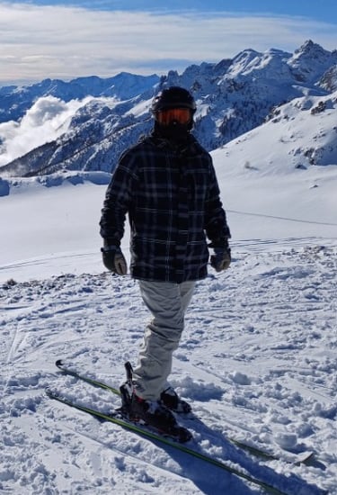 a man standing on a ski slope with a ski in the background