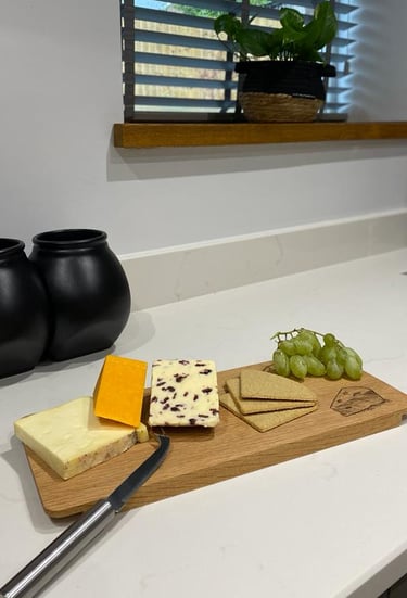 a cheese board with cheese and grapes on a kitchen bench