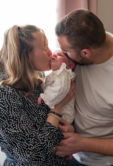 des parents faisant un bisou à leur bébé