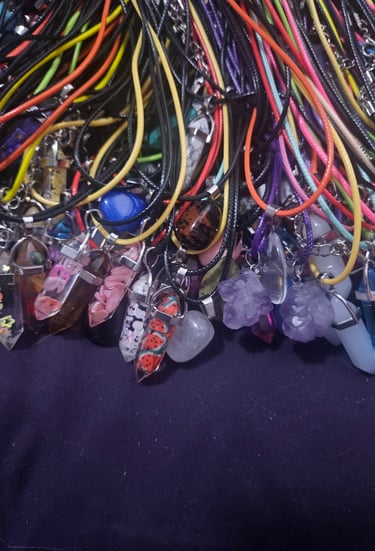 a bunch of different colored cords and stone pendants