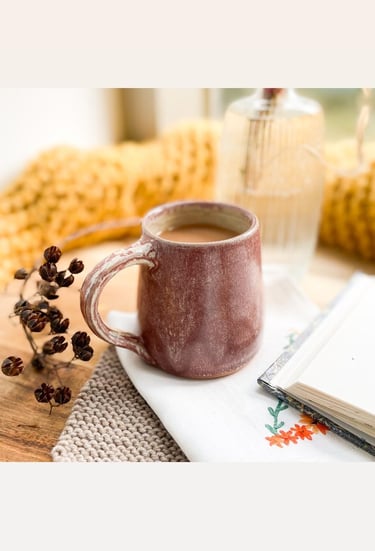A handmade ceramic cup in a relaxed home setting