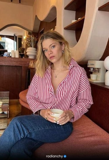 a woman sitting on a couch with a cup of coffee