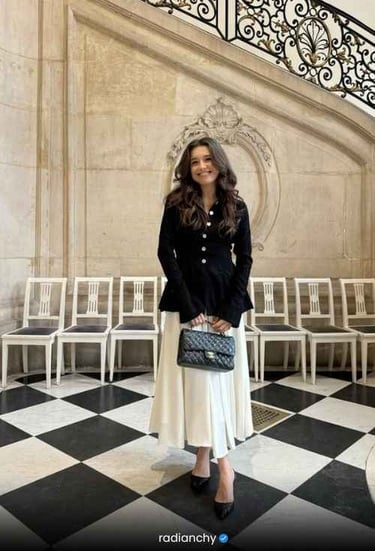 a woman in a black jacket and white skirt