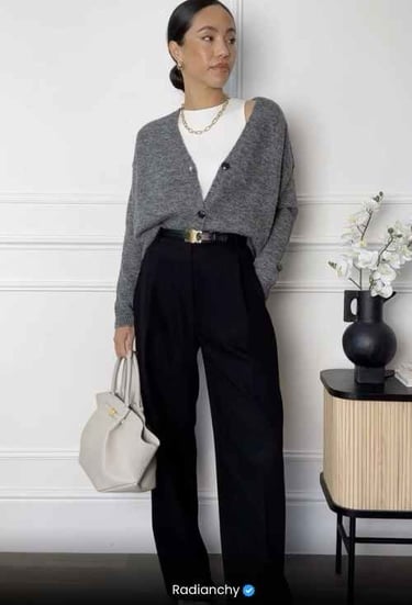 a woman in a gray sweater and black pants