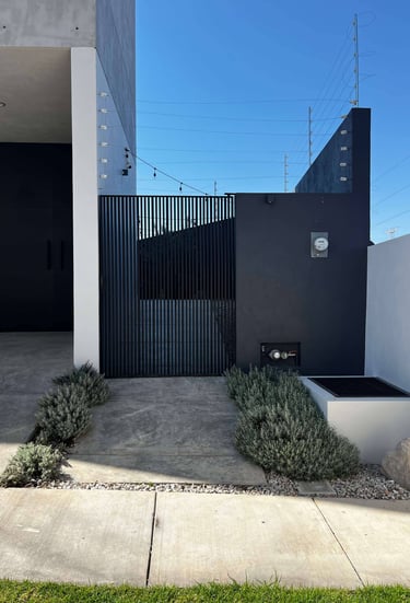 a black and white house with a black gate and a black gate
