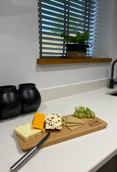 a cheese board with cheese and grapes on a kitchen bench