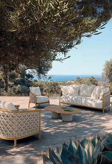 Garden seating with outdoor performance fabric, synthetic wicker, stone surfaces and natural materia