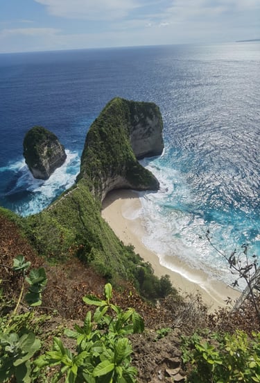 Aerial view of Kelingking Beach in Nusa Penida, Bali, featuring the famous T-Rex shaped limestone cliff and turquoise ocean
