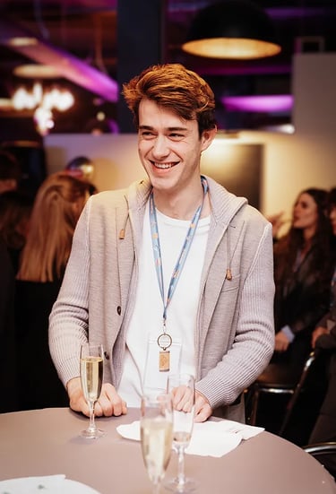 Invité souriant pendant une soirée d’entreprise à Luxembourg, coupe de champagne à la main.