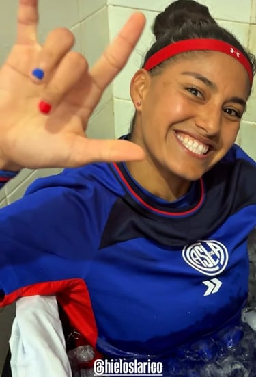 Smiling soccer player in a blue San Lorenzo jersey taking an ice bath recovery session.