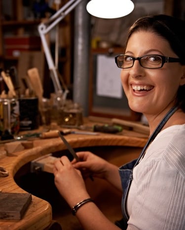 Mujer feliz en su taller haciendo trabajo de macramé hecho a mano 