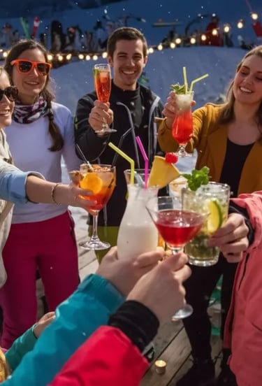A group of friends cheering with colorful cocktails on a snowy outdoor terrace during an après-ski c