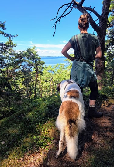 Frau mit Hund in Berglandschaft auf einer Wanderung