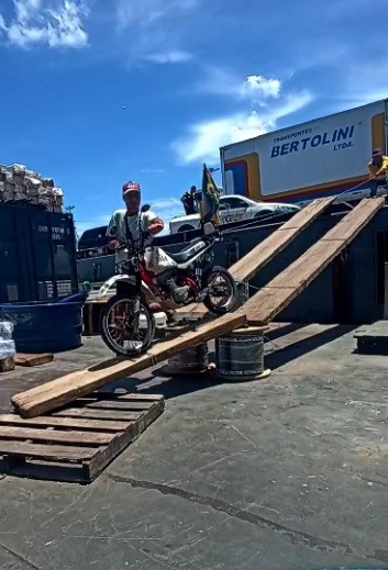 a man is standing on a ramp with a motorcycle