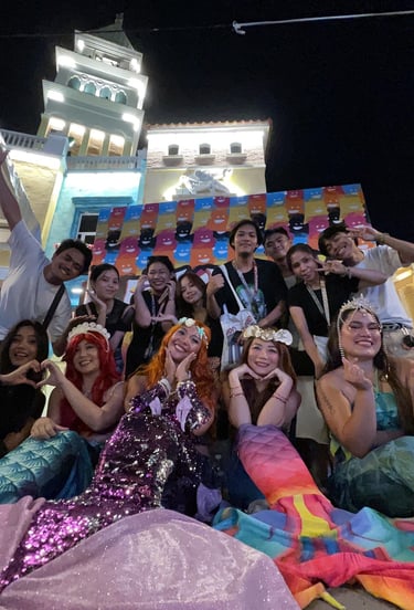 a group of mermaids posing infront of a night light city backdrop