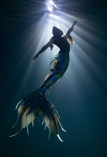 Afa Zhang in beautiful merman costume in mysterious lighting in the ocean. Photo by @pepearcos
