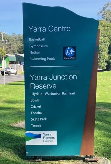 green sign beside the warburton highway in yarra junction sign reads yarra junction reserve and yarra centre 