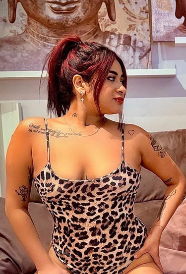 Chica colombiana en body animal print sobre el sofá mostrando su escote
