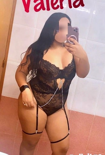 Valeria, escort latina con curvas, vestida en lencería negra con liguero, ofreciendo placer 24 horas en Bellvitge.