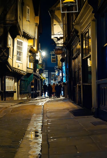 a person walking down a street at night at York shambles