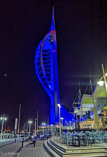 Spinnaker Tower lit up in blue against a dark night sky