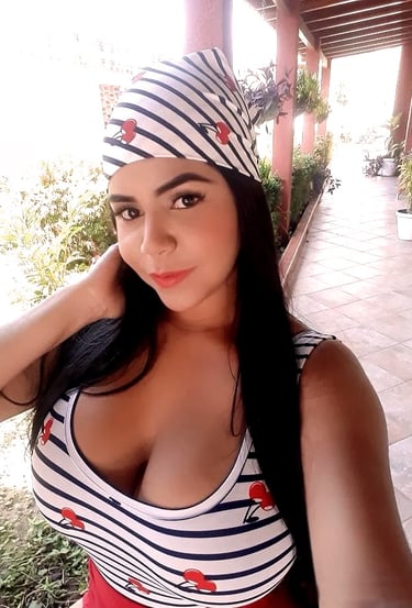 una mujer con un sombrero y un top a rayas