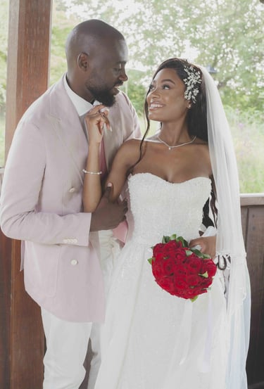 Une mariée et un marié debout dans une tonnelle en bois partageant un regard tendre