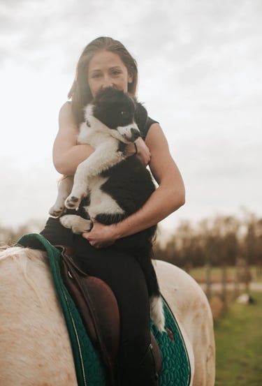 portrait d'une psychologue cavaliere avec son chiot dans les bras