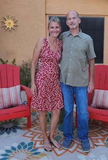 owner and wife standing in front of a house