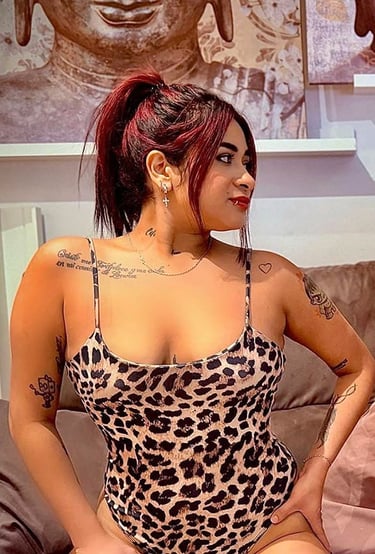 Chica colombiana en body animal print sobre el sofá mostrando su escote