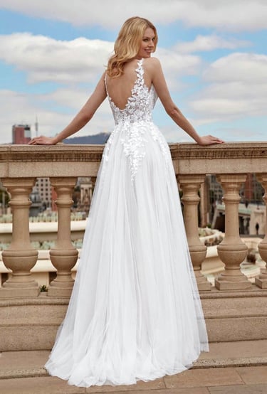 a woman in a white dress standing on a balcony