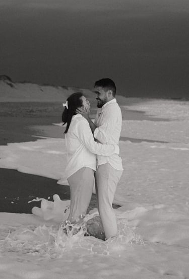 Couple riant les pieds dans les vagues sur une plage de Vendée. Séance photo spontanée et naturelle
