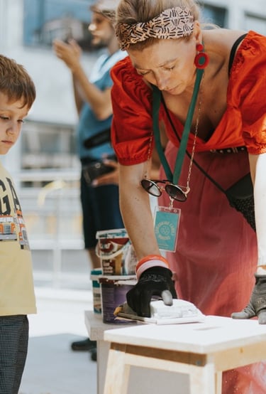 a woman in a red dress is standing in front of a table with a child