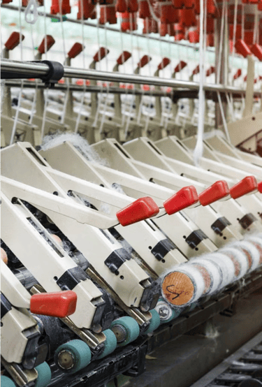 textile fabric manufacturer: A row of looms for textile fabrics