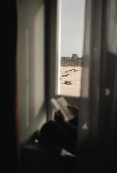Lire face à la plage dans sa chambre d'hôtel