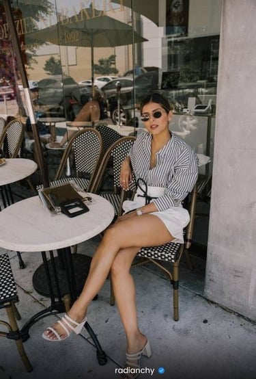 a woman sitting at a table with a laptop