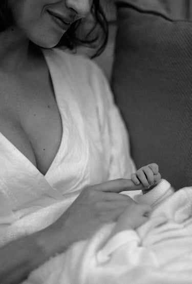 newborn baby holding mothers index finger tight in a lifestyle newborn photography session