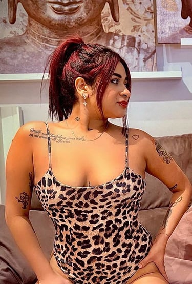 Chica colombiana en body animal print sobre el sofá mostrando su escote