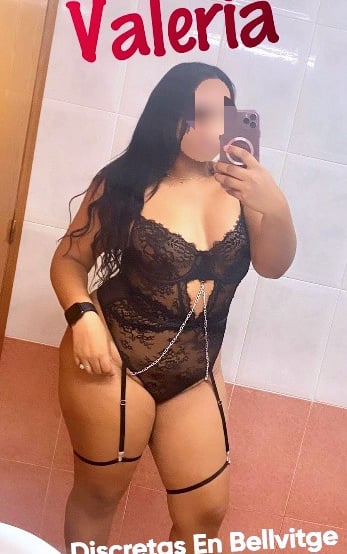 Valeria, escort latina con curvas, vestida en lencería negra con liguero, ofreciendo placer 24 horas en Bellvitge.