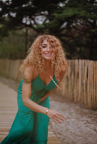 a woman in a green dress and a wooden fence