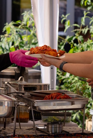 Gäste erhalten frisch serviertes indonesisches Essen auf einem Streetfood Markt
