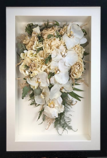 trailing view preserved wedding bouquet with white orchids in a frame