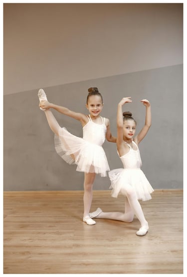 two young girls having fun in white dresses are posing for a photo