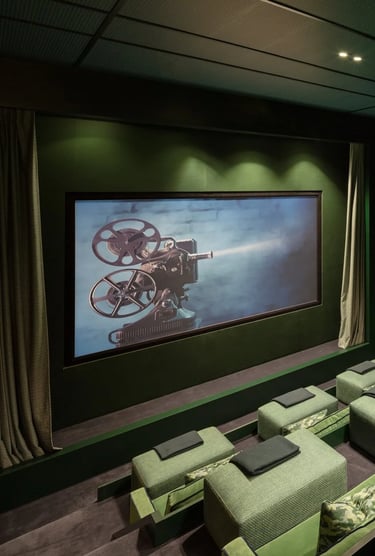 Cinema room at Villa La Gratitud with plush green armchairs