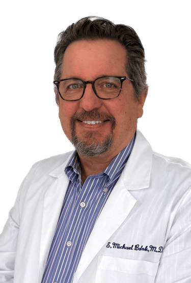 man wearing glasses in a white coat and dress shirt