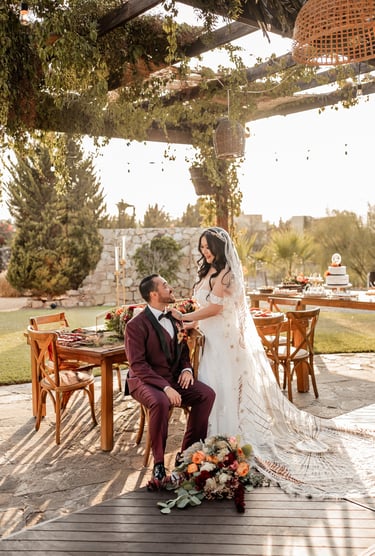 a bride and groom sitting on a deck deck