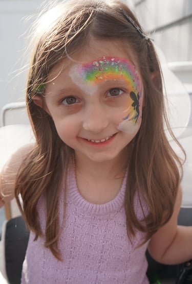Showing off her rainbow face paint