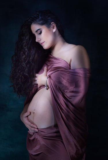 Femme enceinte drapé d'un voile pourpre antique caressant son ventre rond et baissant son regard
